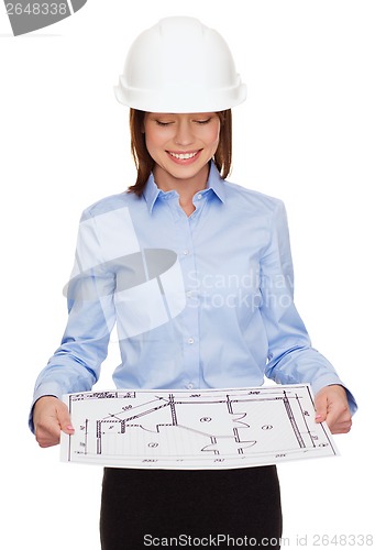 Image of businesswoman in helmet looking at blueprint