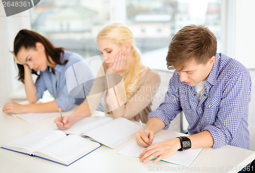 Image of tired students with notebooks at school