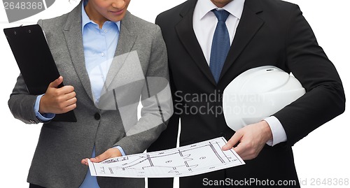 Image of businesspeople with blueprint and helmet