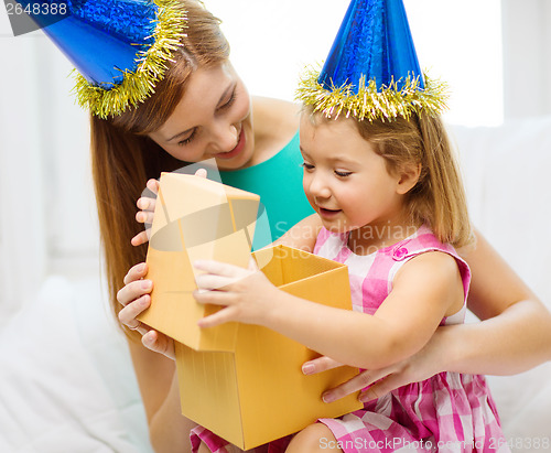 Image of mother and daughter in blue hats with favor horns