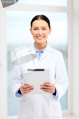 Image of smiling young doctor with tablet pc in cabinet