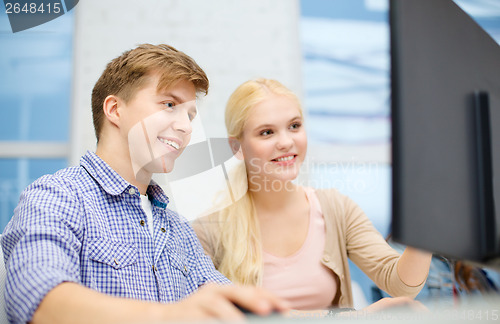 Image of smiling teenage boy and girl in computer class