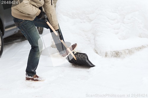 Image of closeup of man shoveling snow from driveway