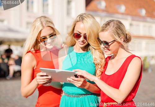 Image of beautiful girls toursits looking into tablet pc