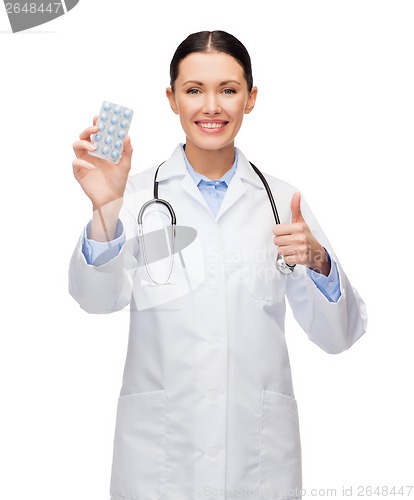 Image of smiling female doctor with stethoscope and pills