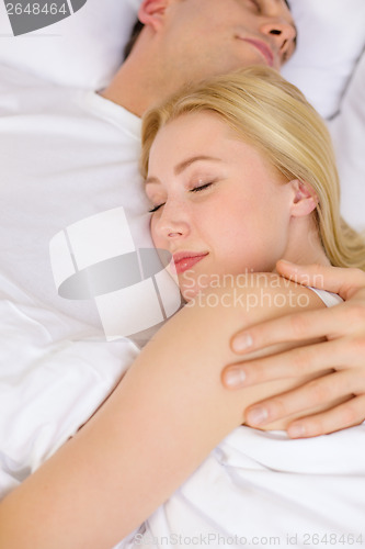 Image of happy couple sleeping in bed