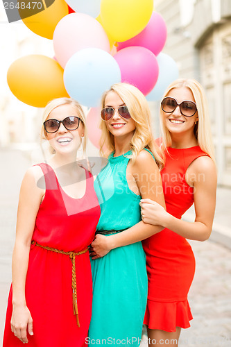 Image of beautiful girls with colorful balloons in the city