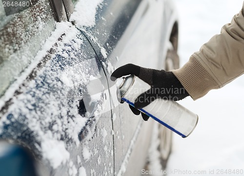 Image of closeup of man hand with lock door de-icer