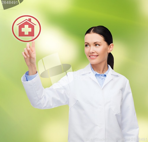 Image of smiling female doctor pointing to hospital sign