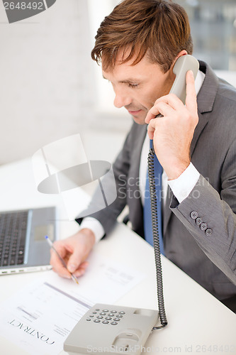 Image of businessman with laptop computer and phone