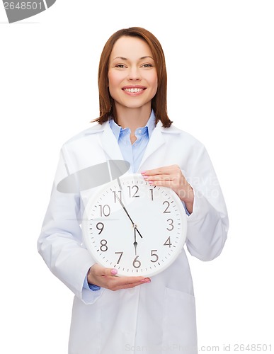 Image of smiling female doctor with wall clock