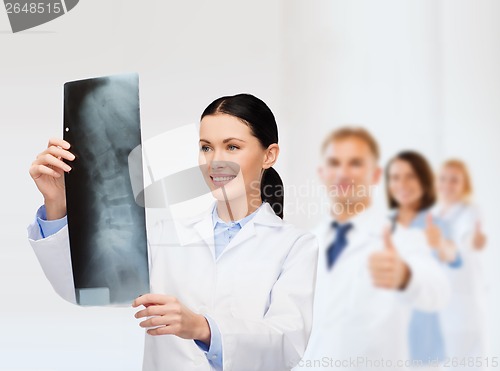 Image of smiling female doctor looking at x-ray