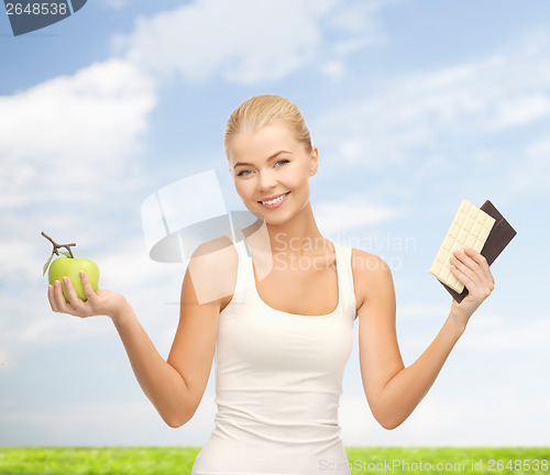 Image of sporty woman with apple and chocolate bars