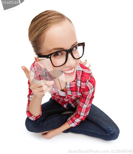 Image of smiling teenager in eyeglasses with finger up