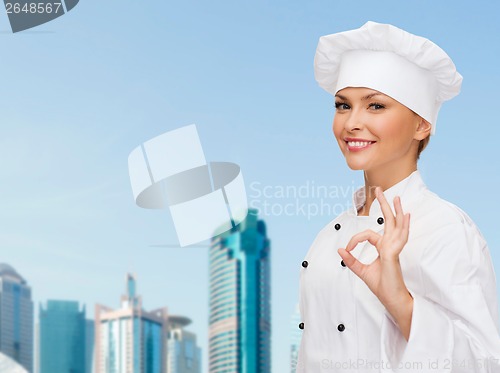 Image of smiling female chef showing ok hand sign