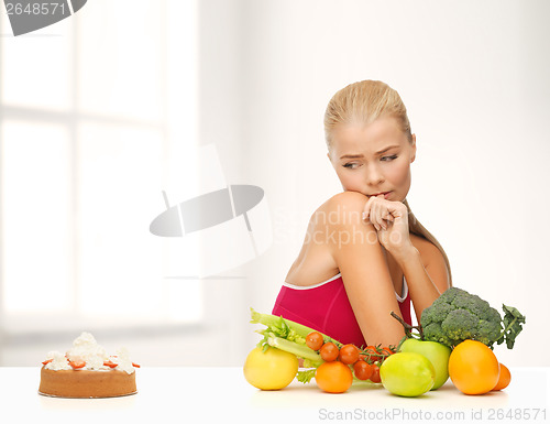 Image of doubting woman with fruits and pie