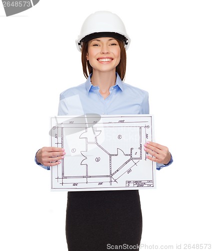Image of smiling businesswoman in helmet showing blueprint