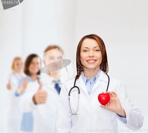 Image of smiling female doctor with heart and stethoscope
