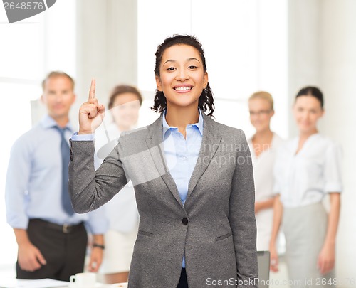 Image of smiling businesswoman with her finger up at office