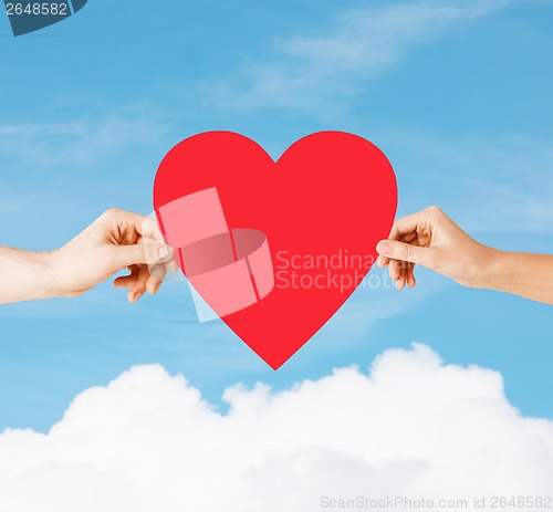 Image of couple hands holding red heart