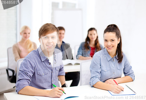 Image of smiling students with notebooks at school