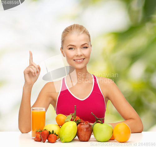 Image of woman with juice and fruits holding finger up