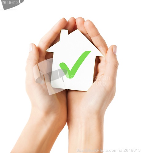 Image of hands holding house with check mark