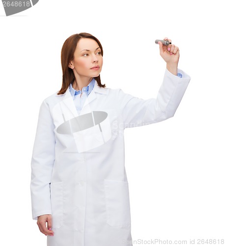 Image of young female doctor writing something in the air
