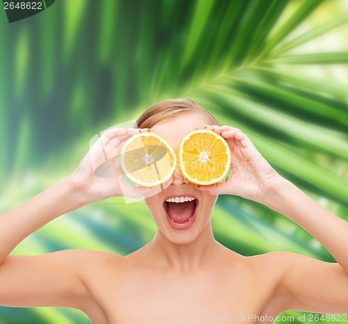 Image of amazed young woman with orange slices