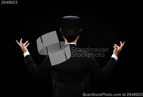 Image of magician in top hat showing trick from the back