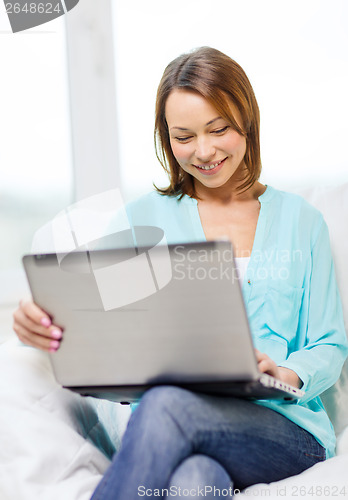Image of smiling woman with laptop computer at home
