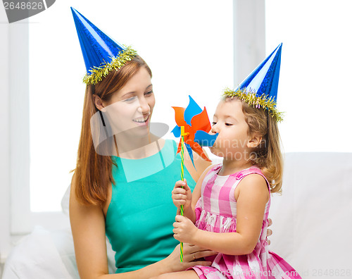 Image of mother and daughter in blue hats with pinwheel