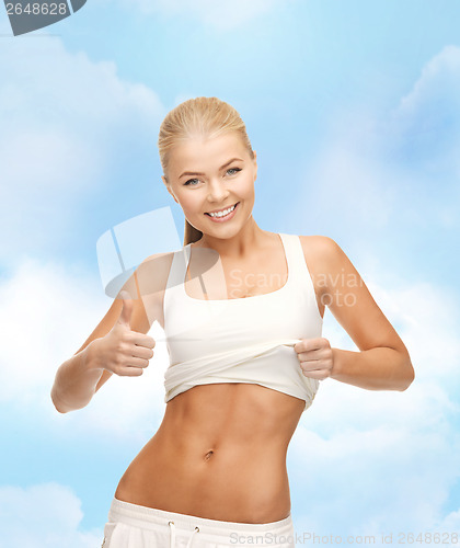 Image of sporty woman showing thumbs up
