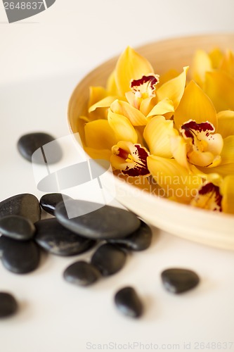 Image of massage stones with flowers on table