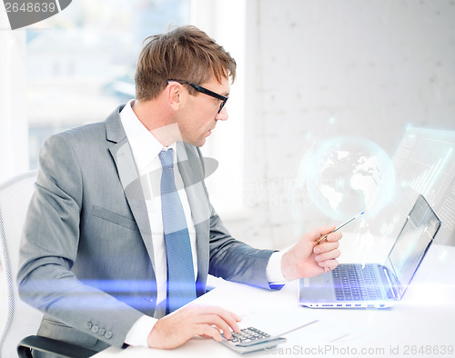 Image of businessman with computer, papers and calculator