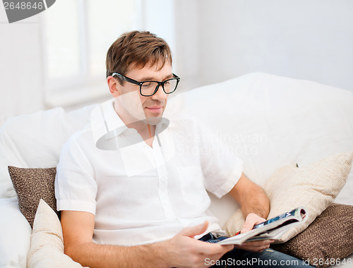 Image of man with magazine at home