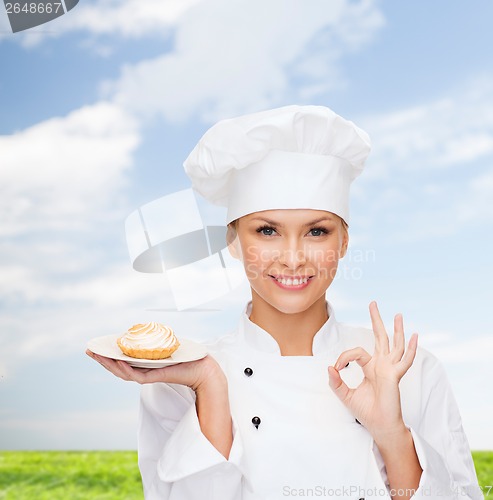 Image of smiling female chef with cake on plate