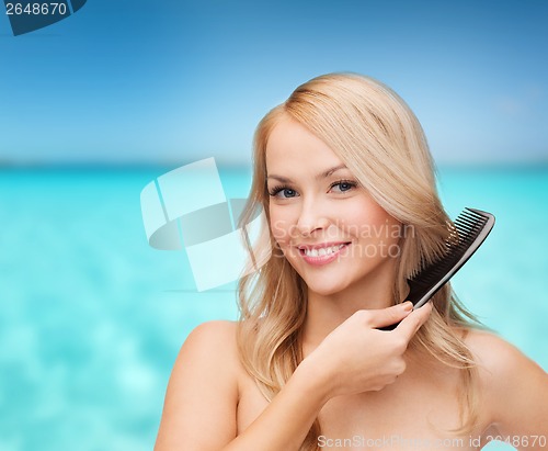 Image of smiling woman with hair brush