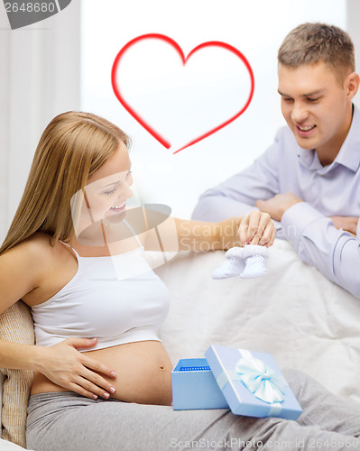 Image of family expecting child with gift box and bootees