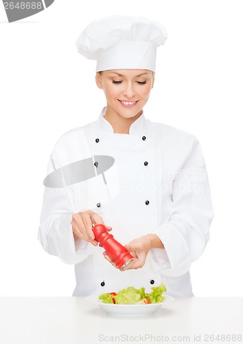 Image of smiling female chef with preparing salad