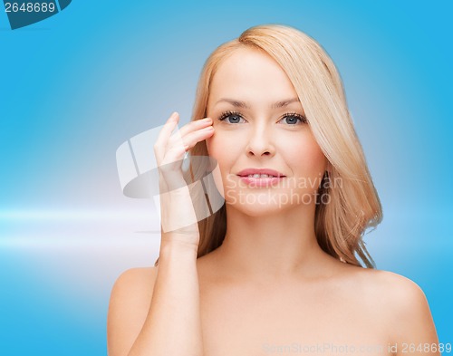 Image of beautiful woman touching her eye area