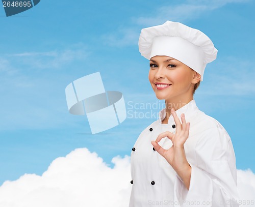 Image of smiling female chef showing ok hand sign