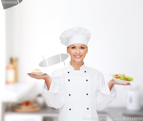 Image of smiling female chef with salad and cake on plates