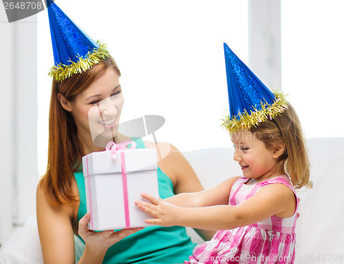 Image of mother and daughter in blue hats with favor horns