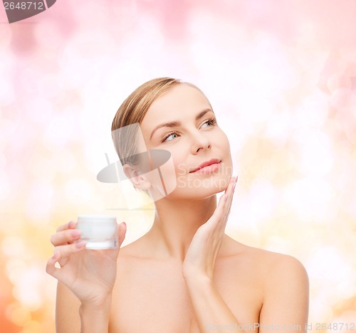 Image of woman applying cream on her skin