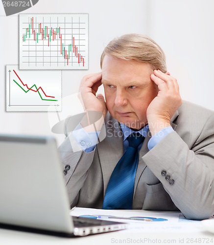 Image of upset older businessman with laptop in office