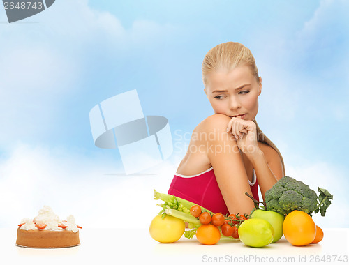 Image of doubting woman with fruits and pie