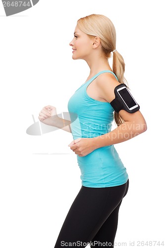 Image of sporty woman running with smartphone