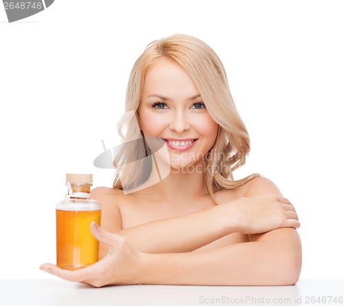 Image of happy woman with oil bottle