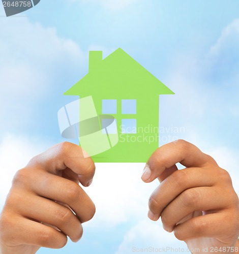 Image of woman hands holding green house